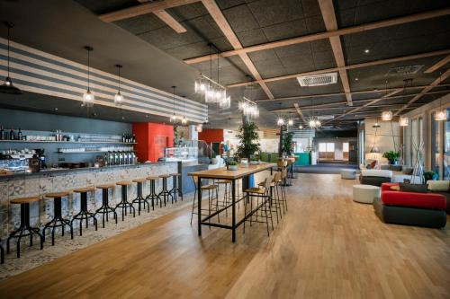 a lobby with a bar and some chairs and tables at JUFA Hotel Weiz in Weiz