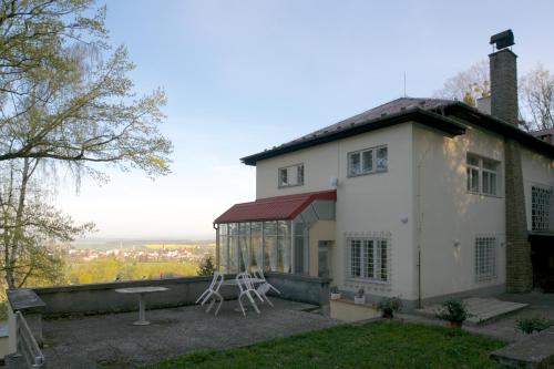 a house with two chairs sitting on the side of it at Sola Gratia in Bystřice pod Hostýnem