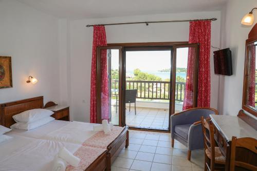 a bedroom with two beds and a balcony at Pandora Studios Skiathos in Skiathos