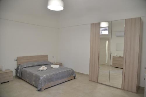 - une chambre avec un lit et un grand miroir dans l'établissement Al borgo di Cappella, à Monte di Procida