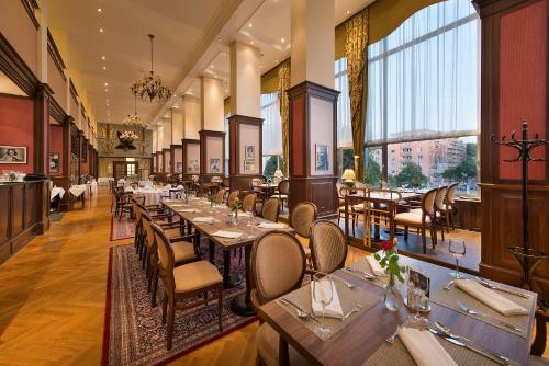 a restaurant with tables and chairs and large windows at Apollo Hotel Bratislava in Bratislava