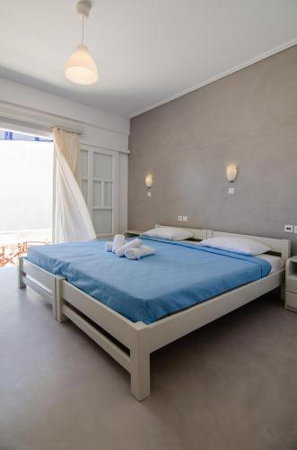 a bedroom with a large bed with blue sheets at Olga in Ios Chora
