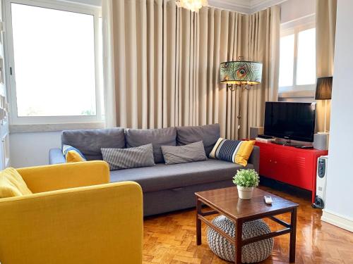 a living room with a couch and a tv at Home Out Central Roma Apartment in Lisbon