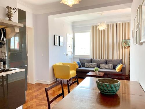 a living room with a couch and a table at Home Out Central Roma Apartment in Lisbon
