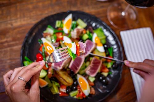 a person eating a plate of food with a salad at Mamma´s Boutique Hotel in Poděbrady