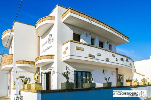 a white building with potted plants on it at B&B Kilometrozero in Supersano