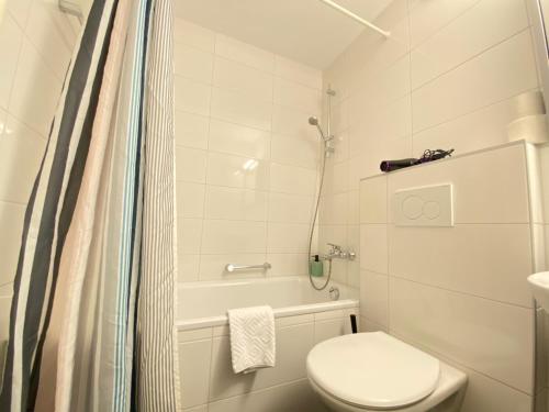 a white bathroom with a toilet and a shower at Galaxy Apartments Lucerne in Luzern