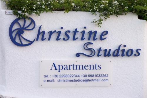 a sign for a christmas studio apartments on a wall at Christine Studios in Poros