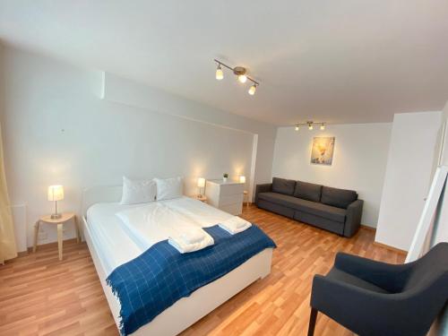 a bedroom with a large bed and a couch at Galaxy Apartments Lucerne in Luzern