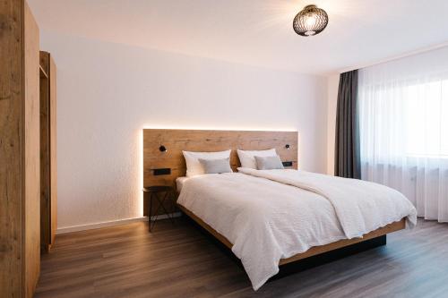 a bedroom with a large bed and a window at Moderne 2 Zi.-FeWo BlackForest Art Barrierefrei Nähe Freiburg in Simonswald