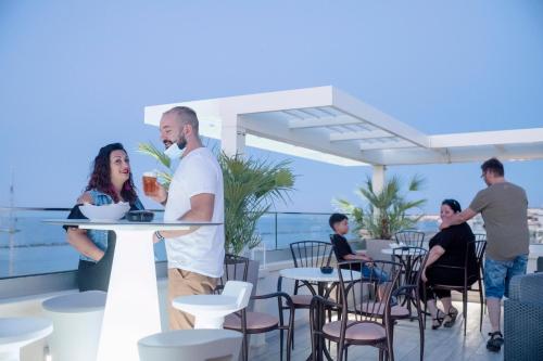 a group of people sitting around a table on a balcony at Hotel Stella D'Oro in Rimini