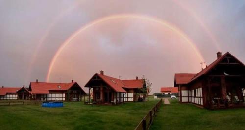 a rainbow in the sky over a group of houses at Domek z basenem nad jeziorem Gwiazdy, Ostoja Bukowo, Kaszuby in Borowy Młyn