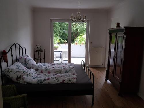 Schlafzimmer mit einem Bett und einer Glasschiebetür in der Unterkunft Ganze Wohnung mit Garten in Bremen