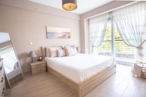 a bedroom with a large bed and a large window at Sani villa perfect for family vacations in Sani Beach
