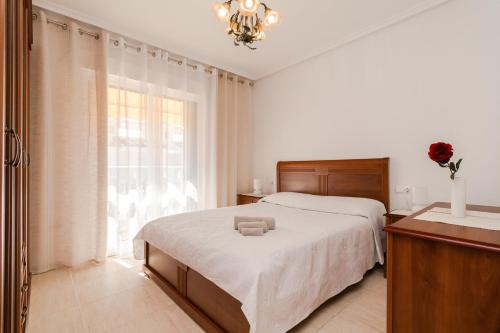 een slaapkamer met een groot bed en een raam bij Espanatour AGUAMARINA in Torrevieja