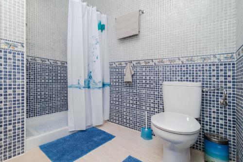 een badkamer met toilet en douche met blauwe tegels bij Espanatour AGUAMARINA in Torrevieja