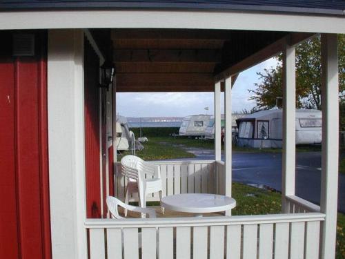 a porch with a table and chairs and tents at Helsingør Camping & Cottages Grønnehave in Helsingør