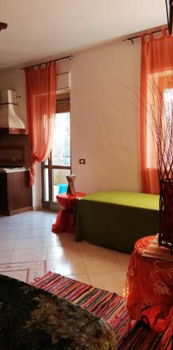 un soggiorno con divano verde e tende rosse di Villa Santa Elena B&B - Country Home Holiday a Sala Consilina