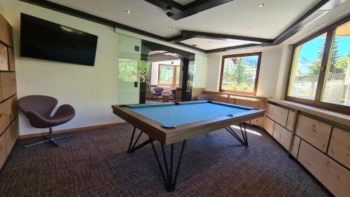 a game room with a pool table and a tv at Hotel Cresta in Samnaun