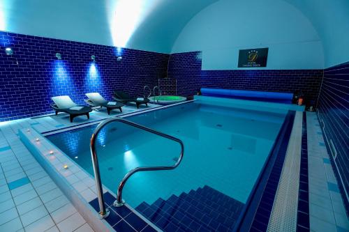 uma piscina com luzes azuis num edifício em LH Hotel Dvořák Tábor Congress & Wellness em Tábor