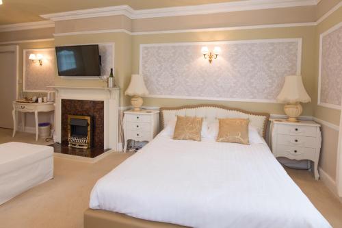 a bedroom with a white bed and a fireplace at Rydal Lodge in Rydal