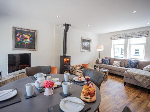 a living room with a table and a fireplace at Squirrel Cottage in Stranraer