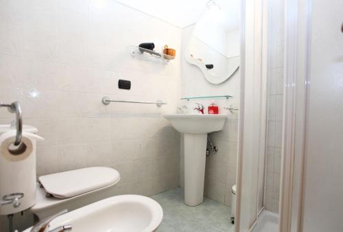 a white bathroom with a sink and a toilet at Taormina Bed and BeerCraft in Taormina