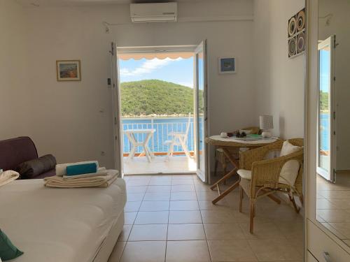 a room with a bed and a table and a balcony at Studio Apartments More in Korčula