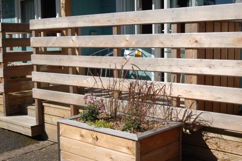 a wooden fence with a planter with plants in it at Woodland Hazel Lodge in Killin