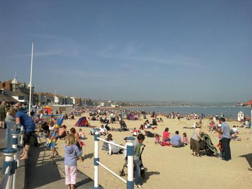 a large crowd of people on a beach at Marjune Guest House in Weymouth