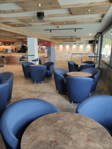 a waiting room with blue chairs and tables at Hotel Internacional in Calella