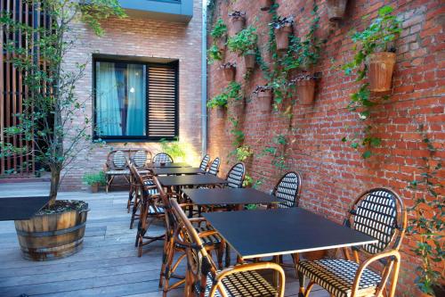 a wooden table and chairs in front of a brick building at Le Berger Hotel in Brussels