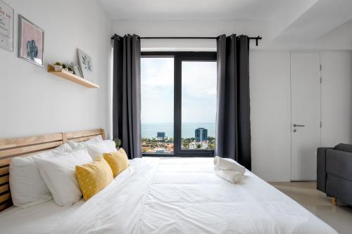 a bedroom with a large white bed with a large window at Muji Studio 1 - Seaview at 218 Tropicana Near Komtar Food Heaven with Netflix & TV Box in George Town