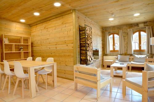 a dining room with wooden walls and a table and chairs at El Jou Nature in Sant Corneli de Cercs 
