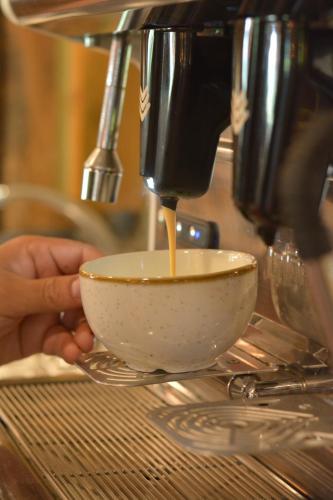 a person is preparing a cup of coffee at El Jou Nature in Sant Corneli de Cercs 