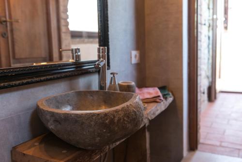a bathroom with a stone sink and a mirror at Agriturismo Schiaccia Ghiande in Massa Marittima