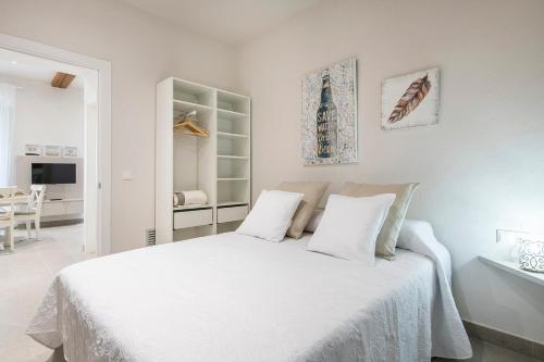 um quarto branco com uma cama grande e lençóis brancos em Lovely & Cozy apartment in the heart of Banyoles em Banyoles