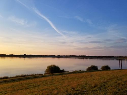 a view of a lake at sunset at Haus am See in Rieste