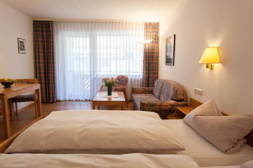 une chambre d'hôtel avec un lit et une chaise dans l'établissement Rustikales Apartment 35qm mit Balkon Nähe Freiburg, à Simonswald