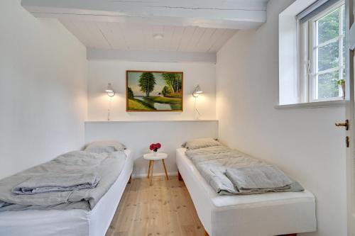 a room with two beds and a table in it at Hørhavegården B&B in Højbjerg
