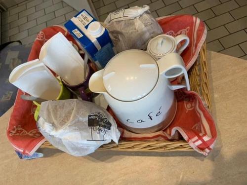 a basket filled with cups and mugs on a counter at Chambr'im Leh in Hoerdt