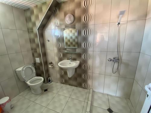 uma casa de banho com um WC, um lavatório e um chuveiro em Guest house Napoli em Ravda