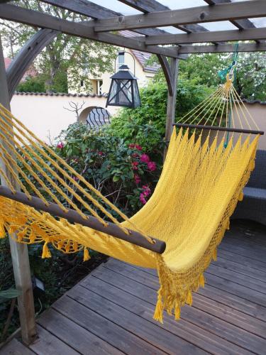 a hammock on a deck with a pergola at Fleur de Vigne in Eguisheim