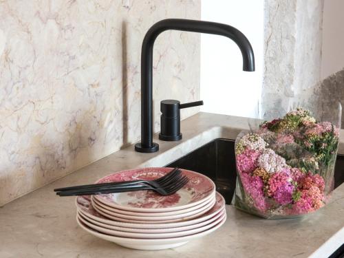 a sink with a stack of plates and a fork at Madalena Orquidea Living Apartments in Lisbon