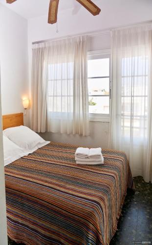 a bedroom with a bed with two towels on it at Hostal Illes Pitiüses in Sant Ferran de Ses Roques