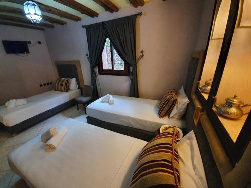 a room with two beds and a window at Dar Assarou - Toubkal National Park Lodge in Imlil