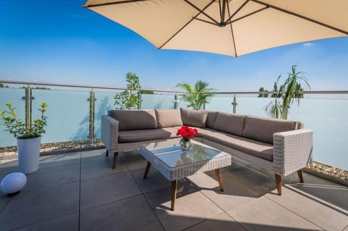 a patio with a couch and a table and an umbrella at Hotel Lantier Wellness & Spa in Bytom