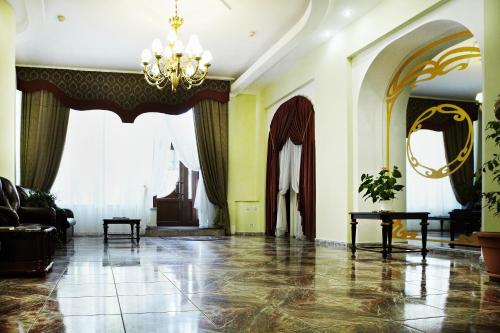 a living room with yellow walls and a chandelier at Astoria Lux in Dnipro