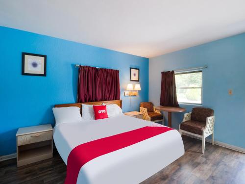 a bedroom with a large bed with a blue wall at OYO Hotel Salem-Roanoke I-81 in Salem
