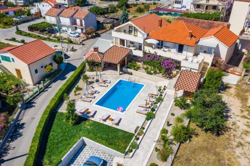 an aerial view of a house with a swimming pool at Merita Apartments with Pool in Sveti Filip i Jakov